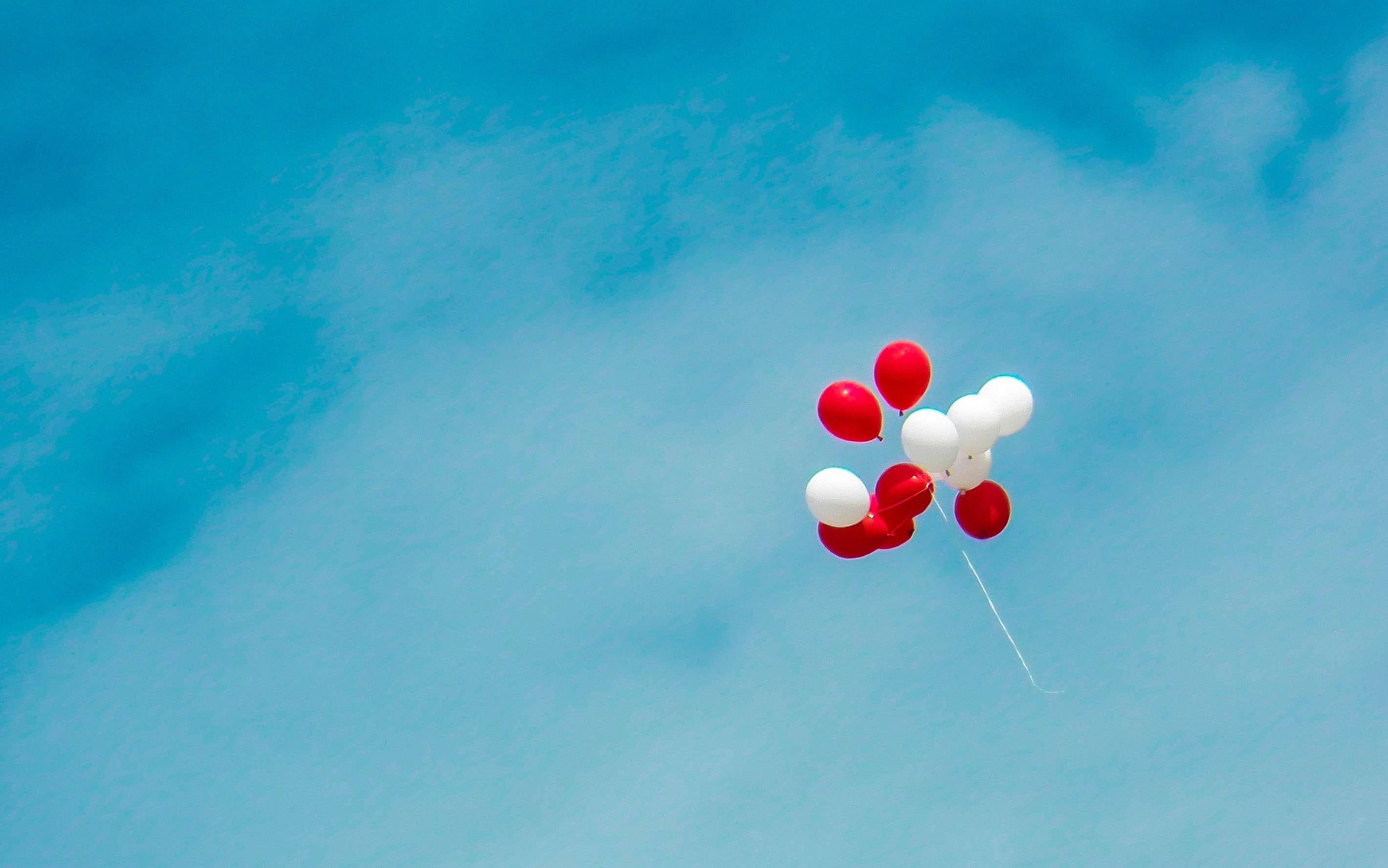 Rote und weisse Ballone, die in der Luft fliegen